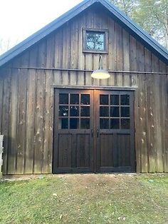 a large wooden building with two doors on the front and one door open to let in light