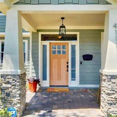 the front entrance to a house with stone pillars and brick walkway leading up to it