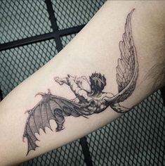 a tattoo on the arm of a man with an angel and demon wings around him