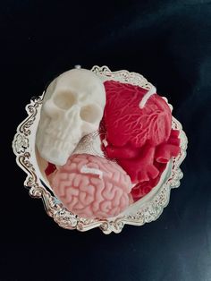 three different types of brain molds in a silver bowl on a black surface,