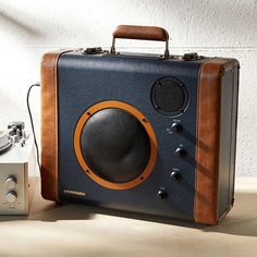 an old fashioned radio sitting on top of a wooden table next to a small camera