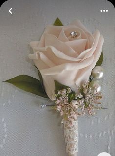 a boutonniere with flowers and pearls on the bottom is shown in this image