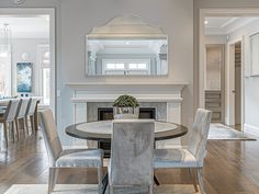 a dining room table with chairs around it and a fireplace in the backround