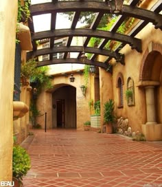 the entrance to an adobe - style home with brick floors and arches