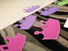 purple and green paper cutouts laying on the floor