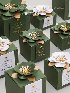 many green boxes with white and gold flowers on them