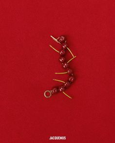 three red beads are arranged in the shape of a tree on top of a red surface