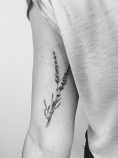 a black and white photo of a person with a flower tattoo on their arm