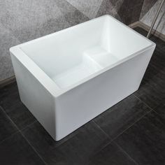 a white bath tub sitting on top of a tiled floor