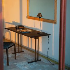 a table with a lamp on it next to a mirror