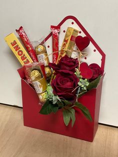 a valentine's day gift box with chocolates, candy and roses in it