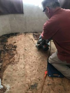 a man using a power drill to fix a hole in the floor that is under construction