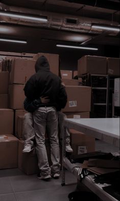 two people standing in front of boxes with one holding the back of another person's head