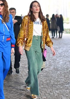 two women walking down the street in matching outfits, one with gold sequins on her jacket