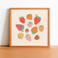 a wooden frame with a painting of strawberries on it next to a wall mounted shelf