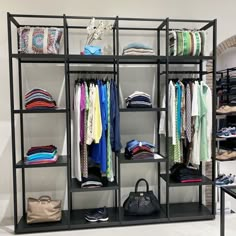 an organized closet with clothes and handbags