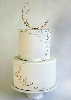 a three tiered white cake with gold sprinkles