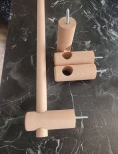 two wooden pegs on top of a marble table with screws in the middle