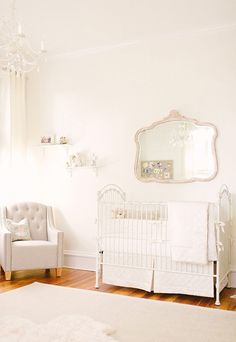 a baby's room with a crib, chair and mirror