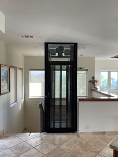 an open door leading to a kitchen and living room with tile flooring on both sides