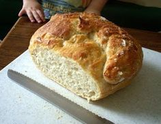 a loaf of bread sitting on top of a white cutting board next to a knife