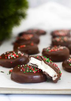 chocolate covered cookies with sprinkles and white frosting