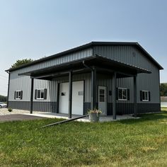 a large metal building sitting on top of a lush green field