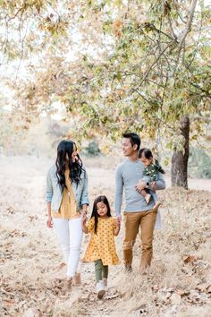 a family walking through the woods holding hands