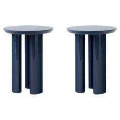 two blue tables sitting next to each other on top of a white surface with black legs