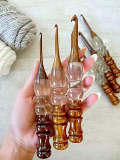 a person holding several small glass objects in their hands, with other items on the table behind them