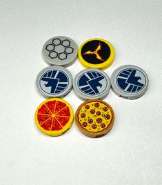 six buttons with different designs on them sitting next to each other in front of a white surface