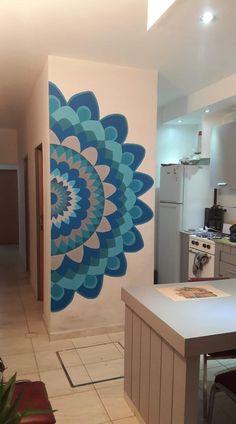 a kitchen with a blue and white flower painted on the wall next to an oven