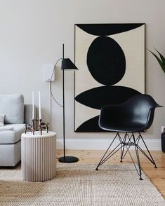 a living room with a black and white painting on the wall