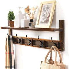 a coat rack with hooks and two coats hanging on the wall next to a bag