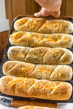 hot dogs are lined up in buns on a baking sheet with cheese and seasoning