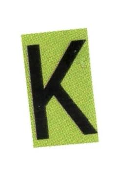 a sticker with the letter k in black on a green square shaped background,