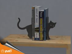 two books are sitting on a shelf with a cat bookend in front of them