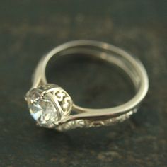 a close up view of a ring with a diamond in the center on a table