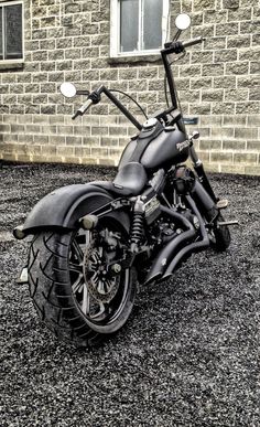 a black motorcycle parked in front of a brick building