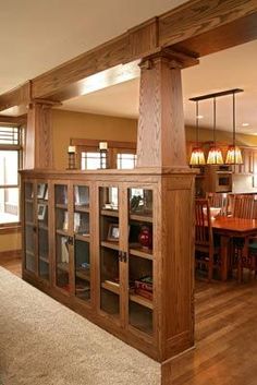 an open kitchen and dining room area with wood flooring, built in bookcases