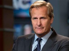 a close up of a person wearing a suit and tie with his arms crossed in front of him