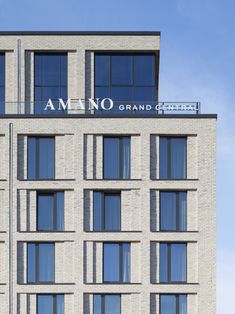 an apartment building with many windows and the name ameno grand