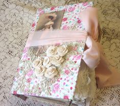 an old photo album covered in fabric and flowers