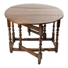 an old wooden table with two legs and a round top, on a white background