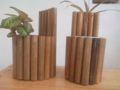 three wooden vases with plants in them on a table