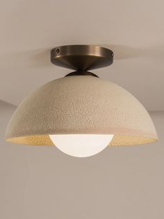 a ceiling light with a white and beige shade on it's face, hanging from the ceiling