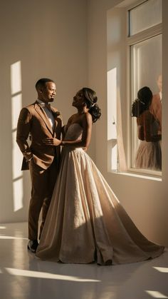 a man and woman standing next to each other in front of a window