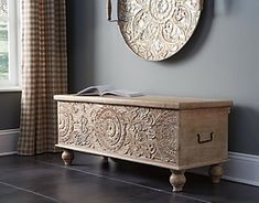 an ornate wooden chest in the corner of a room with a clock on the wall