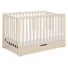 a white crib with two drawers on the bottom