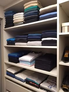 an organized closet with folded clothes and shoes